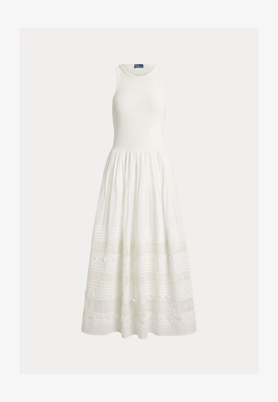 Valge varrukateta maxi-kleit, millel on keha ümber istuv korsett, ümar kaelus ja kogutud seelik, millel on pitsist ja tekstuurse horisontaalse mustriga paneelid.