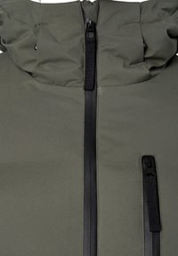 La veste rembourrée verte présente un col montant, une fermeture éclair à l'avant et une poche zippée. Le matériau a une texture lisse avec des accents en métal noir.
