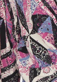 Tela multicolorida con un diseño de patchwork que presenta patrones de paisley en rosa, azul, negro y blanco; textura suave con un caído fluido.