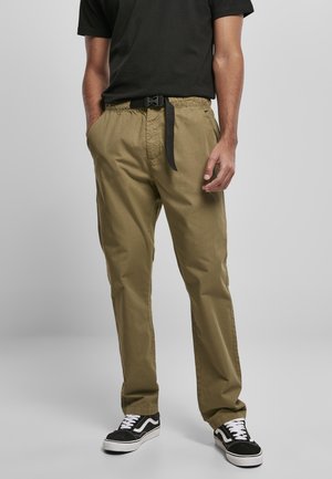 Olive green cotton pants with an elastic waistband and a black webbed belt, paired with black and white sneakers.