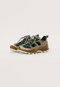 Sport shoes featuring a mix of dark green fabric, brown and beige suede, textured laces, and a rugged pale green outsole.