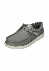 Graue Stoff-Slipper mit einer strukturierten Oberfläche, einer gummierten Sohle in weißer Sprenkel-Optik und einem gefütterten Innenfutter in einem schwarz-weißen Chevron-Muster.
