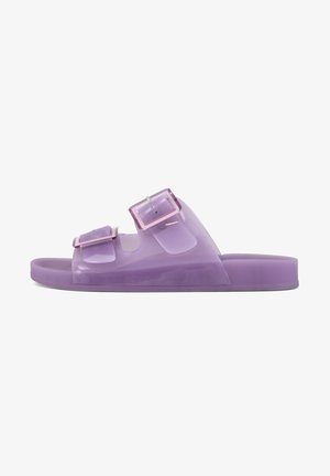 Purple slip-on sandals made of glossy plastic featuring two adjustable buckles, flat sole, and open design for breathability.