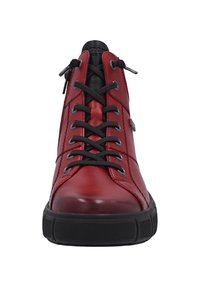 Baskets en cuir rouge avec lacets noirs, bout rond, semelle en caoutchouc texturé noir, détail de surpiqûres sur les côtés et accents noirs au niveau de la languette.