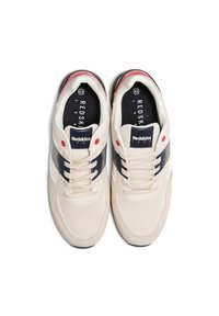 Zapatillas beige con materiales de malla y ante, con acentos en azul marino y rojo, un collar acolchado y una suela de goma. Cordones en un estilo tradicional.