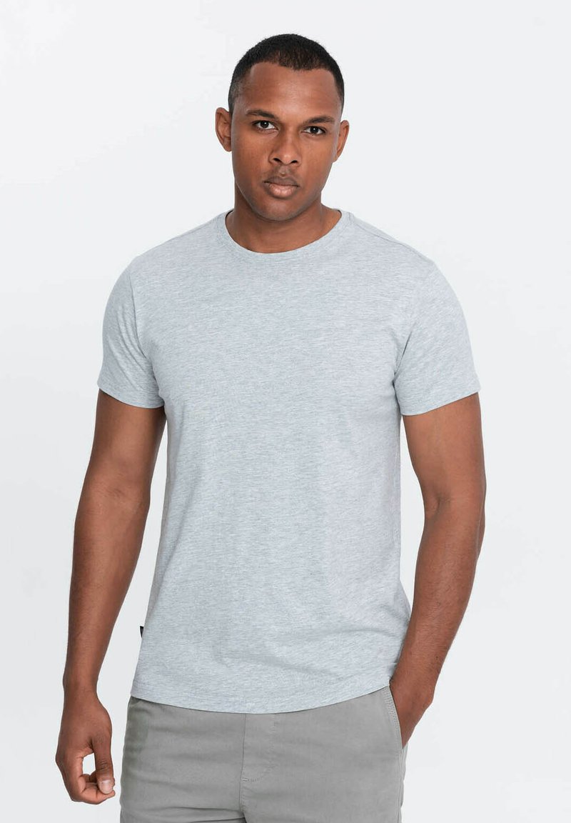 Lys grå bomulds t-shirt med rund hals og korte ærmer. Glat tekstur, almindelig pasform og et diskret meleret mønster over det hele.