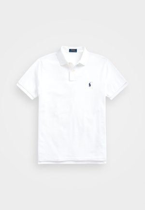 Balts polo krekls, izgatavots no kokvilnas, ar klasisku apkakli, īsām piedurknēm un mazu tumši zilu logotipu kreisajā krūtī. Divu pogu aizdare.