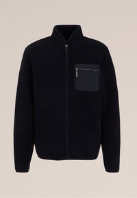 Svart fleecejacka med ståkrage, hel dragkedja och en vänster bröstficka med kontrasterande dragkedja. Mjuk textur genom hela jackan.