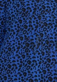 Tessuto blu con motivo a stampa di leopardo nero, arricchito da paillettes nere che formano le lettere 'YO' e 'M'. Texture morbida.