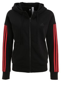 Sweat à capuche noir à fermeture éclair avec une poche avant, doté d'accents rouges à trois bandes sur les manches et d'une capuche à cordon. Confectionné en tissu doux.