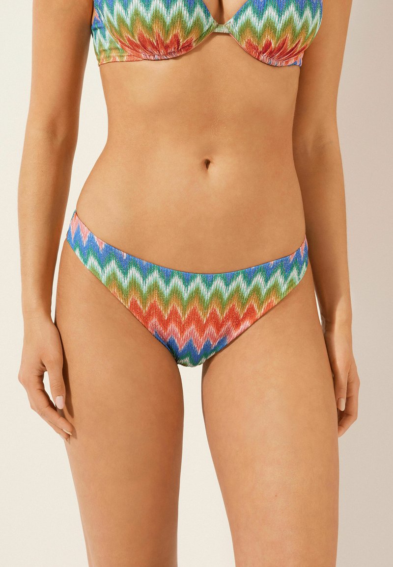 Färgglad bikiniunderdel med ett zigzagmönster i grön, blå, röd och rosa. Tillverkad av ett strukturerat material, med låg midja och minimal täckning.