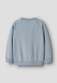 Sudadera azul claro con cuello redondo, mangas raglán y puños de canalé. Tejido suave con textura blanda, sin patrones ni gráficos visibles.