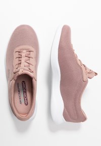 Světle růžové síťované sportovní boty s bílými podešvemi, vybavené texturovaným svrškem, designem na šněrování a štítkem "Memory Foam" na stélce.