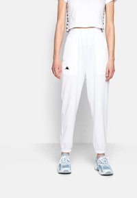 Vita cargobyxor med två framfickor och elastisk midja. Matchar med en kortärmad vit skjorta med svarta sidodekor.