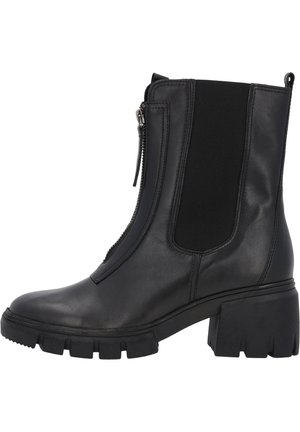 Schwarze Lederstiefelette mit seitlichen elastischen Einsätzen, Reißverschluss, klobigem Absatz und rutschfester Gummisohle. Glatte Textur mit minimalistischer Gestaltung.