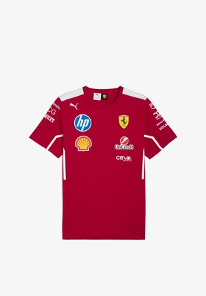 Punane lühikeste varrukatega jers söb hi on valmistatud siledast kangast, valgete detailide ja mitme sponsori logoga, sealhulgas Ferrari embleem rinnal.