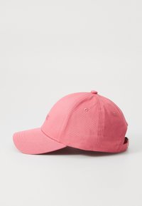 Casquette de baseball rose avec un visière incurvée, fabriquée en tissu doux et texturé. Elle possède une sangle à l'arrière pour un ajustement et un petit logo.
