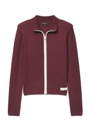 Maglione bordeaux a manica lunga, a coste, con zip bianca e una piccola etichetta "BE CASUAL" vicino all'orlo inferiore su sfondo bianco.