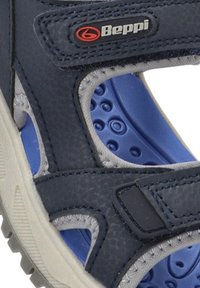 Sandalia azul marino con acentos grises, hecha de material sintético. Cuenta con una plantilla acolchada con detalles texturizados en azul y correas ajustables.