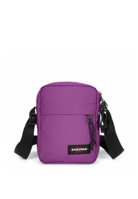 Sac bandoulière violet de forme rectangulaire, fabriqué en tissu durable. Comprend une poche zippée sur le devant, une sangle réglable et un patch logo.