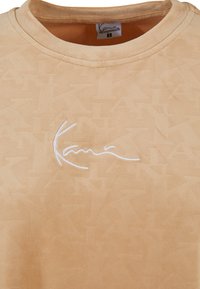 Bežinė apvali kaklo marškinėliai, minkšta tekstūra, iškilmingas raidžių raštas, su baltu siuvinėjimu logotipu. Etiketėje nurodyta dydis S.