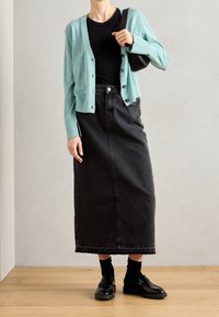 Light blue cardigan, black fitted top, black denim maxi skirt, and black loafers. Smooth texture with buttons on the cardigan.