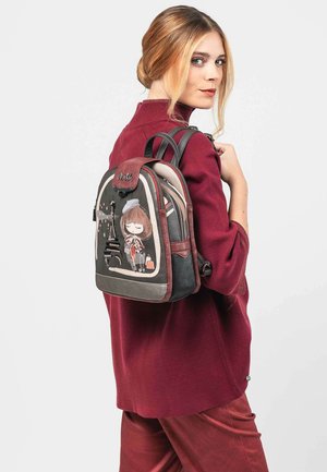 Mochila negra y gris con un diseño de caricatura de una niña y la Torre Eiffel, con detalles de cuero, correas ajustables y un cierre a presión.
