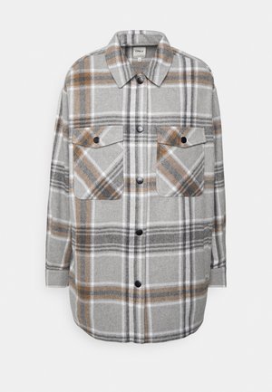 Chemise à carreaux gris avec des accents orange et blancs, dotée de deux poches poitrine, d'une fermeture boutonnée à l'avant et de manches longues. Texture de tissu douce.