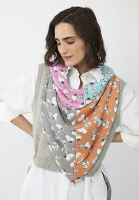 Mehrfarbiger Schal mit Snoopy-Mustern in Pink, Hellblau, Grau und Orange, aus weichem Stoff und in dreieckiger Form, über einer grauen Weste drapiert.
