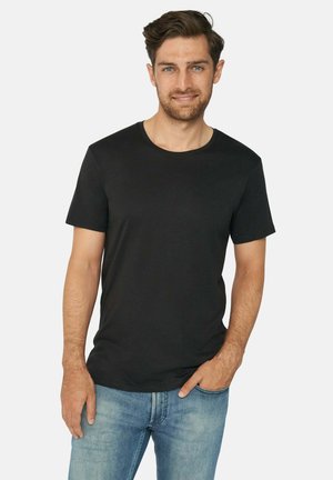 Svart bomull t-shirt med rund halsringning och korta ärmar, tillsammans med ljusblå denimjeans. Standard passform, slät textur.