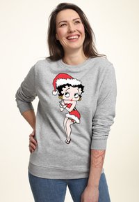 Sudadera gris con un gráfico de caricatura colorido de un personaje vestido con un atuendo de Santa rojo y ribetes blancos, cuello redondo y puños de canalé.