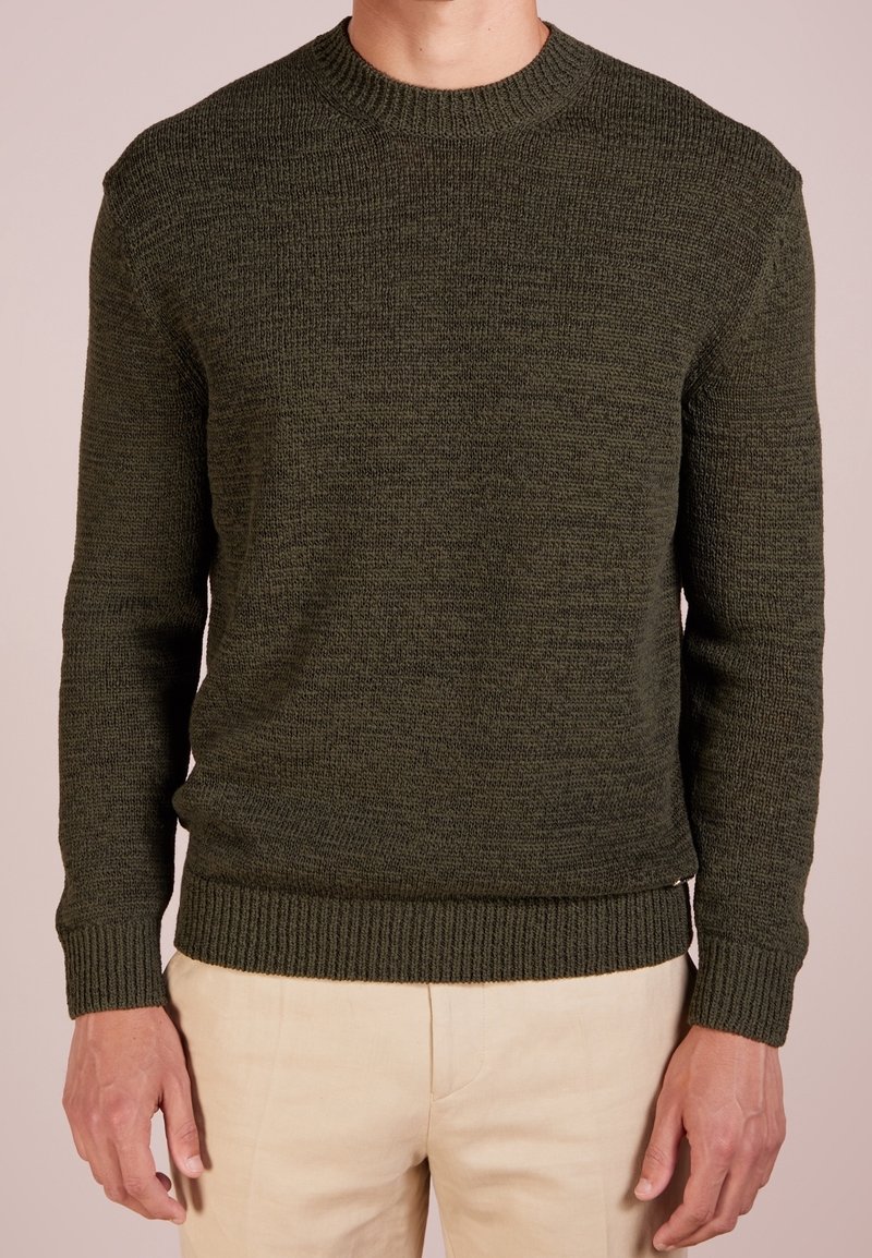 Stickad olivgrön tröja med rund halsringning, ribbade ärmslut och nederkant. Strukturerat tyg med mjukt avslut, figurnära design.