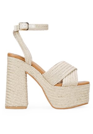 Sandalias de plataforma de cuerda trenzada con un tacón grueso y cuadrado, que cuentan con una amplia tira cruzada y una correa ajustable en el tobillo en un color beige claro.