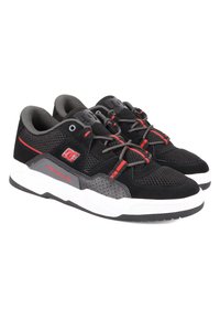 Schwarze Sportschuhe mit einem Obermaterial aus Mesh, grauen Akzenten, roten Details, gepolstertem Kragen und weißer Gummisohle. Mit markiertem Logo an der Seite.