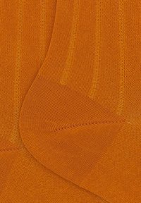 Orangene gestrickte Socken mit geripptem Muster, glattem Stoff und unterschiedlichen Designs. Das Modell fühlt sich an den Zehen und der Ferse nahtlos an.