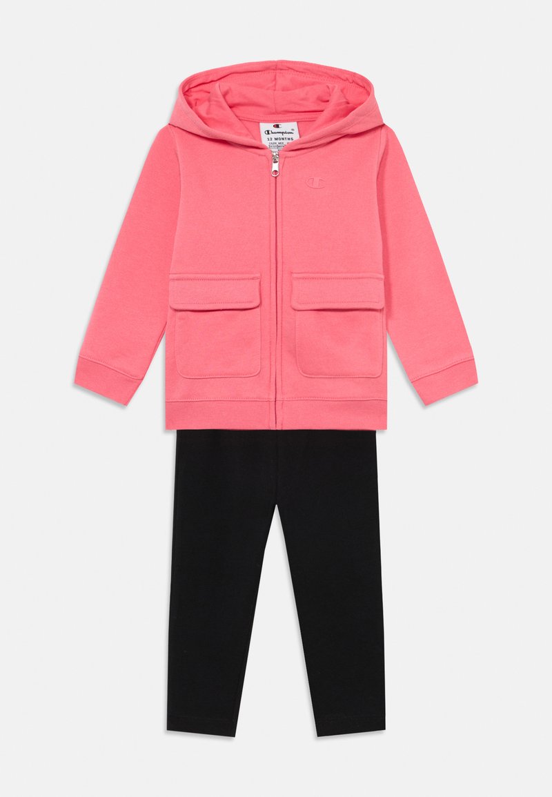 Rozā ar rāvējslēdzēju augšdaļa ar divām priekšējām kabatām un melna naktsbikses pāris. Mīksts audums, vienkāršs dizains, piemērots maziem bērniem.