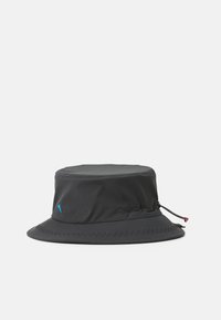Schwarzer Bucket Hat mit glatter Textur, verstellbarem Zugband und Zickzacknähten entlang des Schirms. Hat ein kleines Logodetail an der Seite.