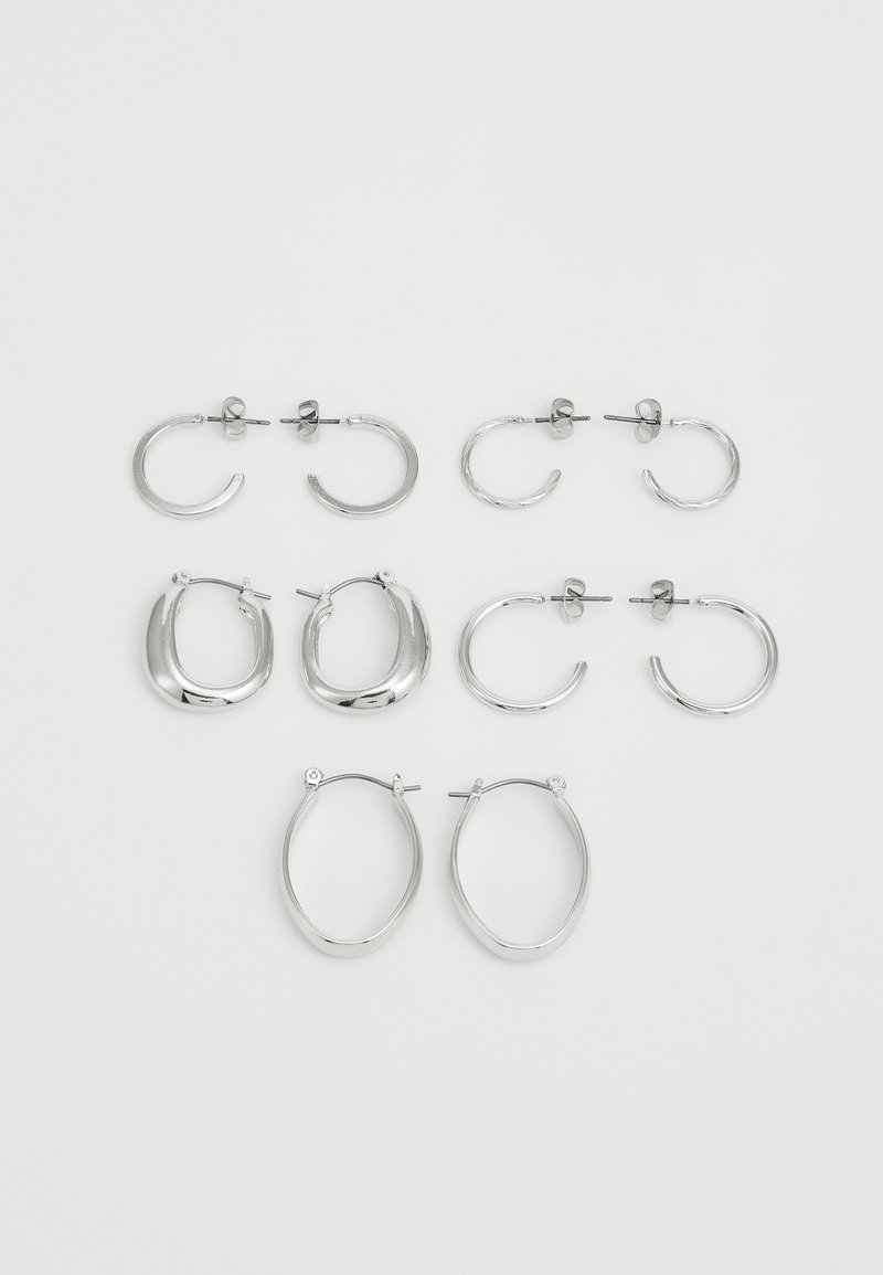 Set von silbernen Ohrringen in unterschiedlichen Stilen: drei Paar Creolen, zwei Paare mit strukturierten Oberflächen, die verschiedene Formen und Größen aufweisen.