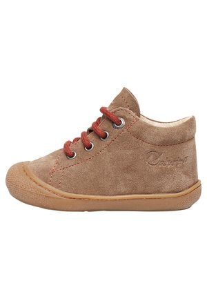 Brun ruskind børnesneaker med gummisål, røde snørebånd, metaløjer og logo prægning på siden, vist i profil på hvid baggrund.
