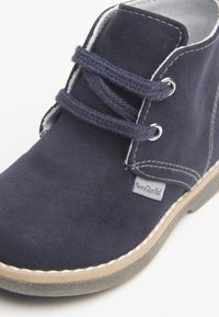 Marineblaue Wildleder-Schnürschuhe mit beiger Sohle und weißen Nähten, ausgestattet mit einem "NeroGiardini" Markenlabel an der Seite.