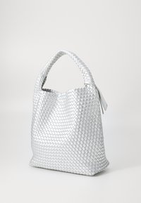 Υφασμένη ασημένια τσάντα χεριού με στρογγυλή λαβή και υφή, που διαθέτει ευρύχωρο, μαλακό σώμα χωρίς ορατά αξεσουάρ ή λεπτομέρειες.