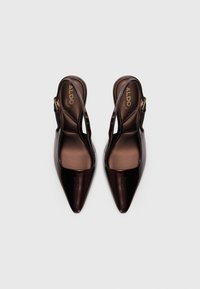 Tummanruskeat kärjelliset slingback-korkokengät, joissa on kiiltävä pinta ja kultainen solki, merkitty ALDO, valkoista taustaa vasten.