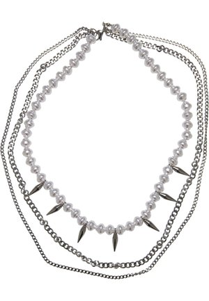 Collier superposé avec un rang de perles blanches irrégulières et des pointes métalliques, entrelacé avec deux chaînes argentées.