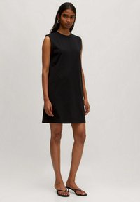 Schwarzes ärmelloses Kleid mit geradem Schnitt, aus glattem Stoff. Minimalistisches Design, knielanger Saum und keine sichtbaren Muster oder Verzierungen.