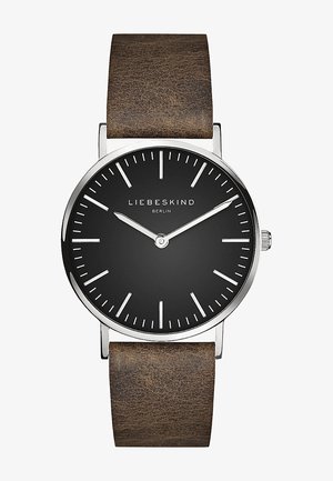 Sort ur med sølvhus; hvide timemarkeringer; brun læderrem; minimalistisk design; ingen tal, enkle time- og minutvisere.