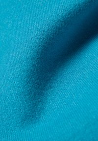 Nahaufnahme eines strukturierten blauen Stoffes mit sichtbarem Webmuster und subtilen Falten.