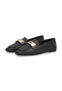 Mocassins noirs perforés avec une garniture en cuir noir lisse et un accent de boucle métallique. Ils présentent une semelle plate et un design à bout arrondi.