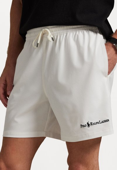 Balti sportiniai šortai pagaminti iš lengvos medžiagos, turi elastinę juostą su raišteliu, šonines kišenes ir juodą išsiuvinėtą logotipą.