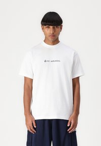White cotton t-shirt with short sleeves, featuring a small black text logo "HUF WORLDWIDE." on the chest.