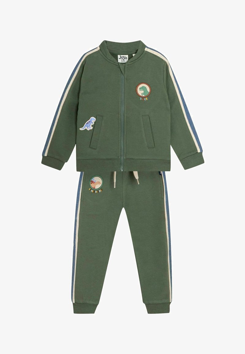 Zelená tepláková súprava vyrobená z mäkkej tkaniny. Skladá sa z bundy na zips s nášivkami a pruhovanými detailmi, doplnenej o nohavice s elastickým pásom.